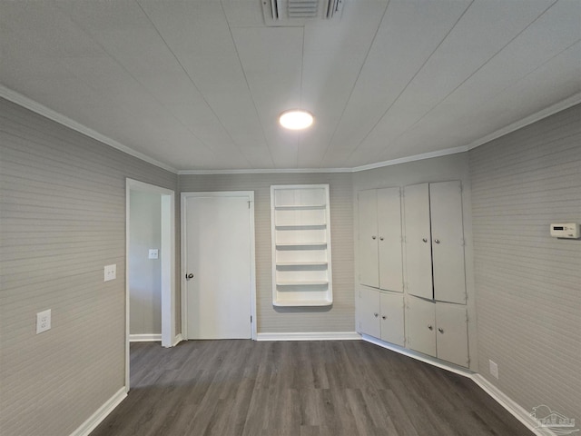 unfurnished bedroom featuring baseboards, ornamental molding, dark wood finished floors, and visible vents