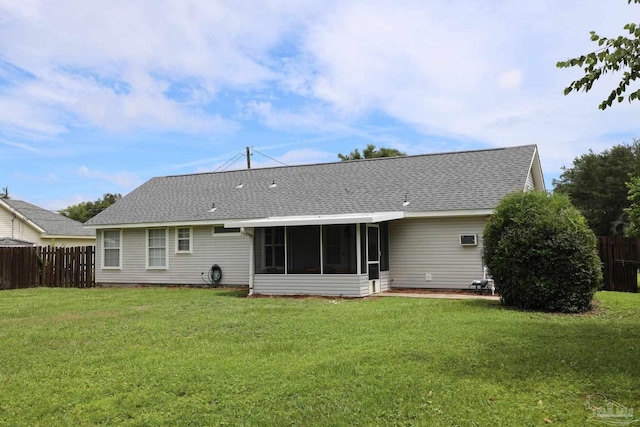 rear view of property featuring a yard and a sunroom