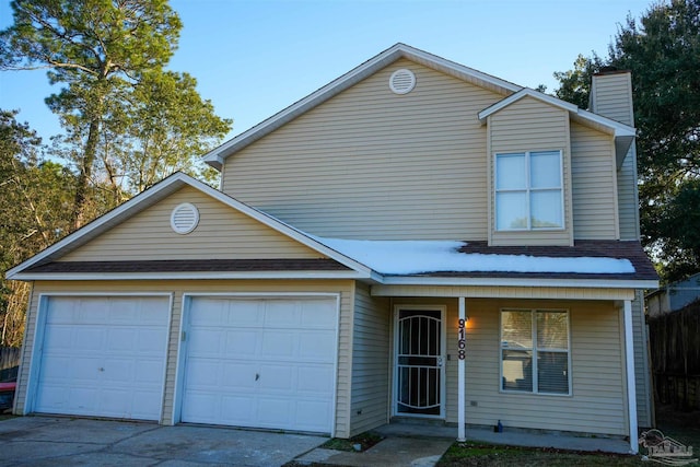 traditional-style home with a garage, concrete driveway, a porch, and a chimney