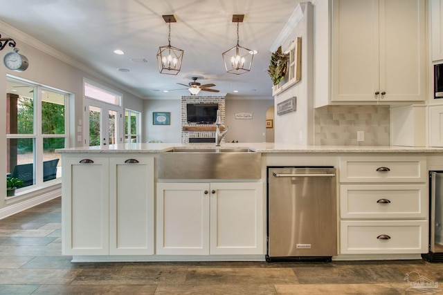 kitchen featuring light stone counters, crown molding, and decorative light fixtures