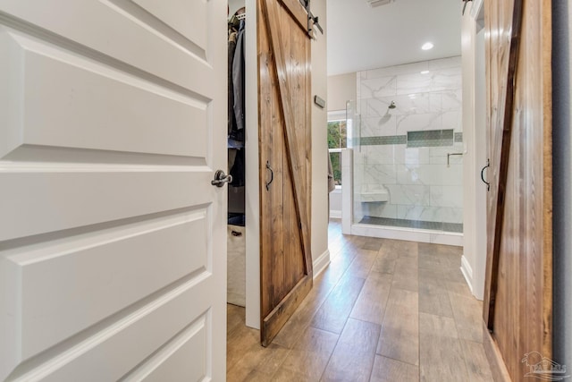 bathroom featuring wood-type flooring and tiled shower