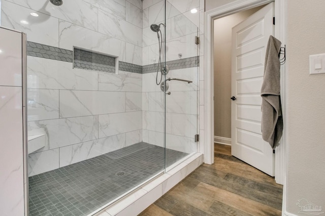 bathroom featuring an enclosed shower and wood-type flooring