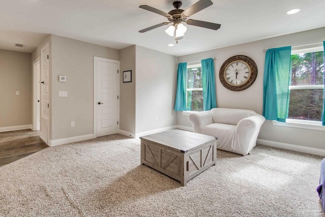 living room featuring ceiling fan and carpet