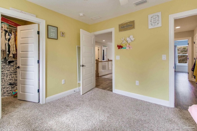 unfurnished bedroom featuring a walk in closet and carpet