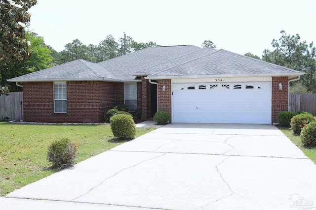 ranch-style home featuring a garage, a front lawn, fence, brick siding, and driveway