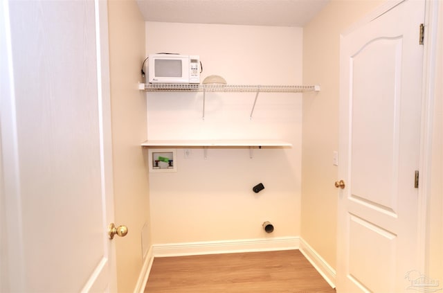 laundry room with laundry area, washer hookup, baseboards, light wood-type flooring, and hookup for an electric dryer