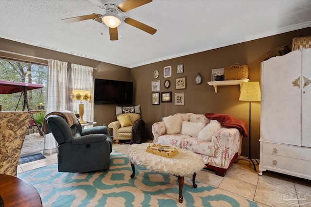 living area with a ceiling fan, tile patterned flooring, crown molding, and a textured ceiling