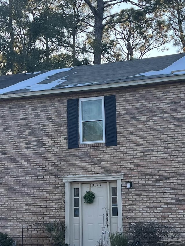 entrance to property featuring brick siding