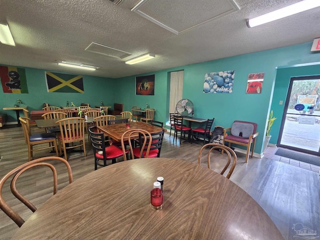 dining space with hardwood / wood-style flooring and a textured ceiling