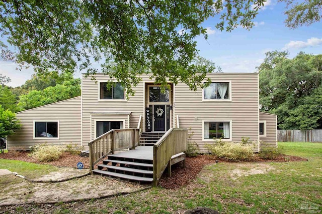 rear view of house featuring a yard and a deck