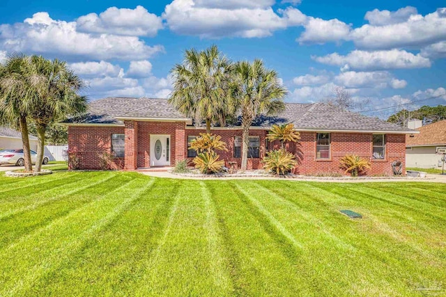 back of house featuring brick siding and a lawn