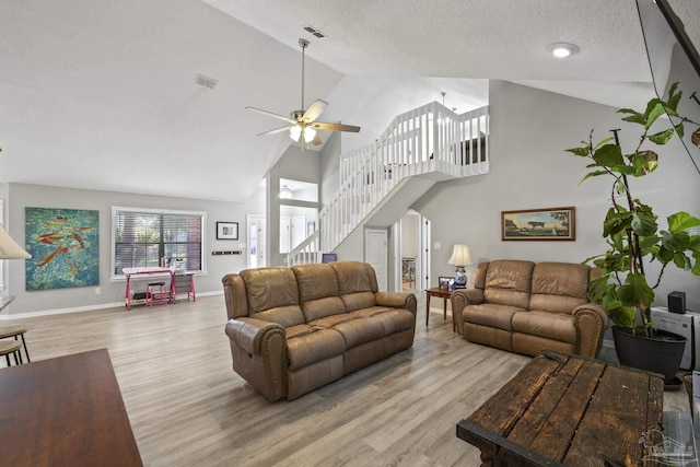 living area featuring visible vents, stairway, wood finished floors, a textured ceiling, and a ceiling fan