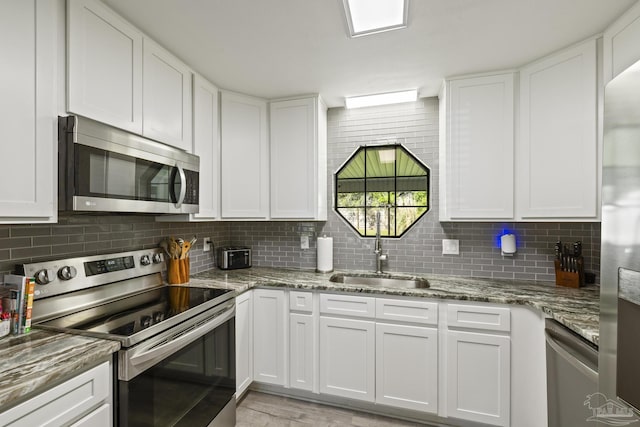 kitchen featuring decorative backsplash, appliances with stainless steel finishes, and a sink