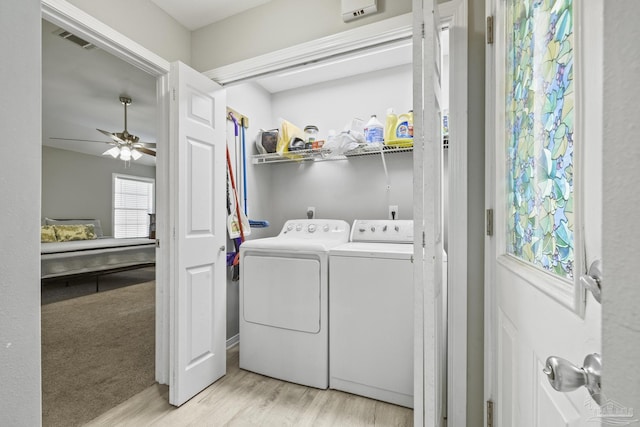 clothes washing area with a ceiling fan, visible vents, light wood finished floors, washing machine and clothes dryer, and laundry area