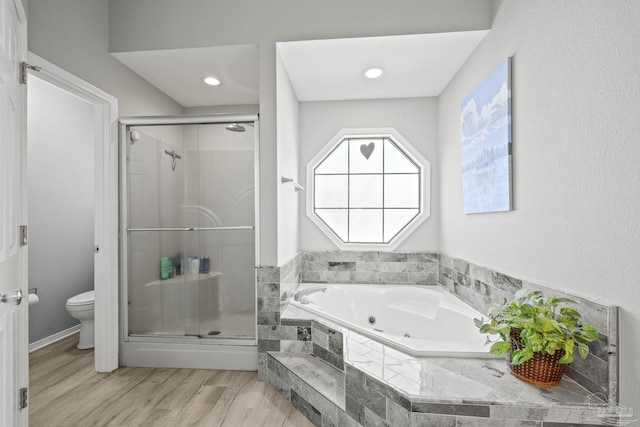 full bath featuring a shower stall, a jetted tub, toilet, and wood finished floors