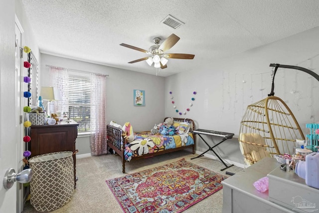 bedroom with visible vents, baseboards, ceiling fan, carpet flooring, and a textured ceiling