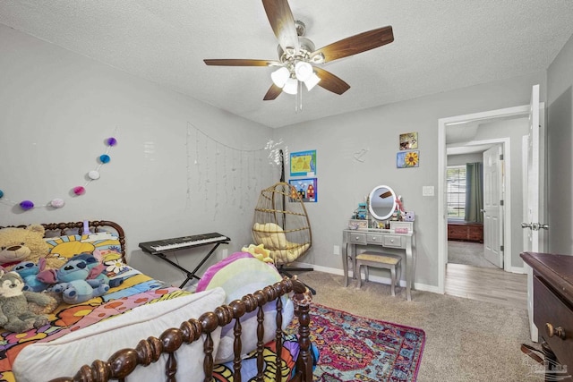 carpeted bedroom featuring ceiling fan, a textured ceiling, and baseboards