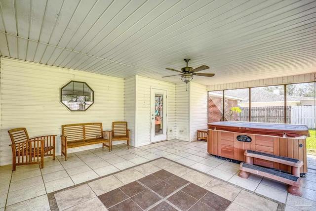 view of patio / terrace with a ceiling fan, fence, and a hot tub