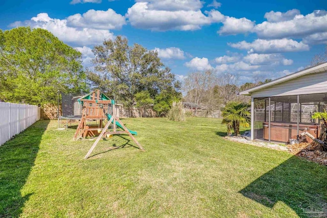 view of yard featuring a trampoline, a fenced backyard, and a playground