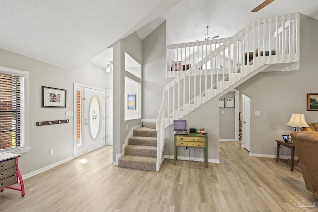 foyer with wood finished floors, stairway, a ceiling fan, and baseboards