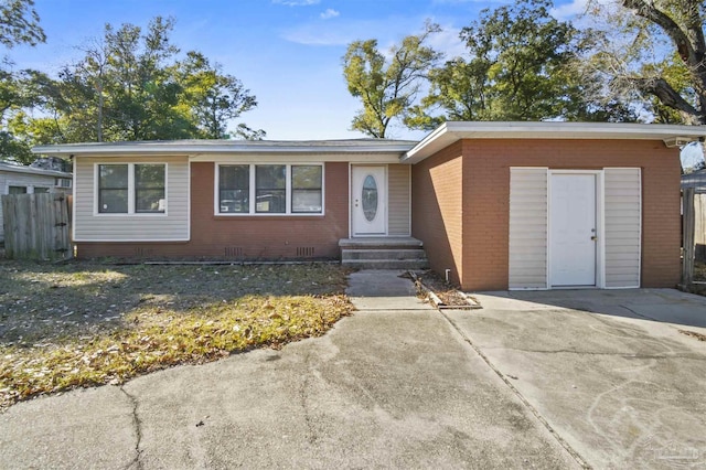 ranch-style home featuring entry steps, brick siding, crawl space, and fence