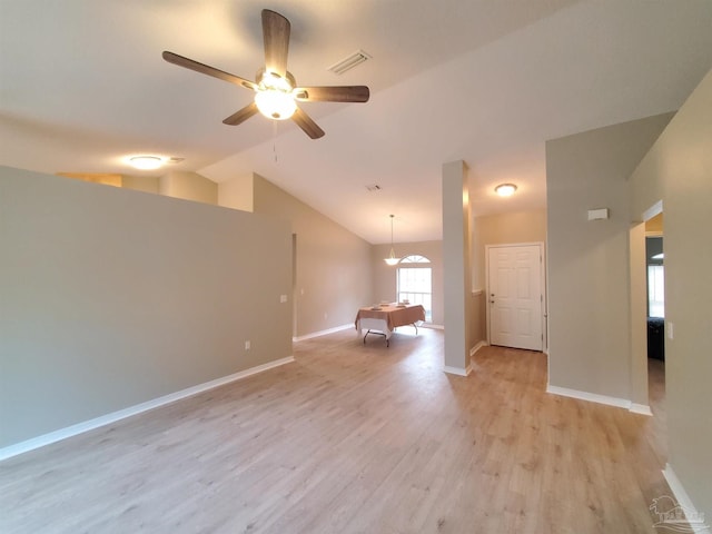 empty room with ceiling fan, vaulted ceiling, and light hardwood / wood-style flooring