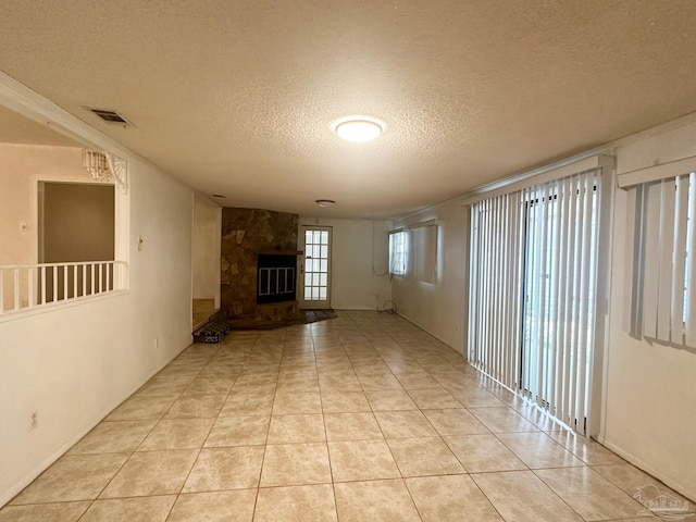 4681 Kingston Dr, Pensacola, FL 32526 - unfurnished living room with a textured ceiling, a fireplace, and light tile patterned floors