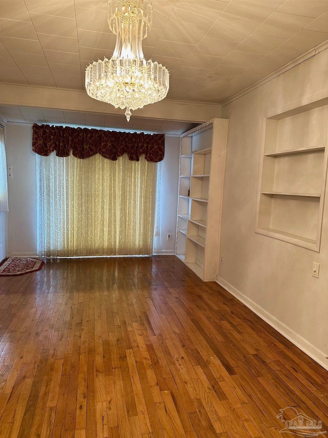 4681 Kingston Dr, Pensacola, FL 32526 - unfurnished room with built in shelves, baseboards, a chandelier, hardwood / wood-style floors, and ornamental molding