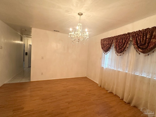 4681 Kingston Dr, Pensacola, FL 32526 - spare room featuring a chandelier and light wood-style flooring
