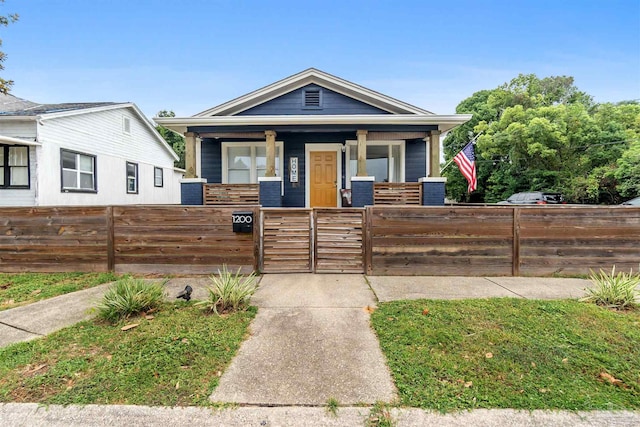 view of front of house with covered porch, a fenced front yard, and a gate