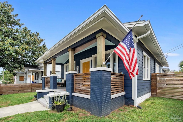 view of side of home featuring a porch and a yard