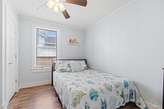 bedroom with hardwood / wood-style floors, ornamental molding, and ceiling fan