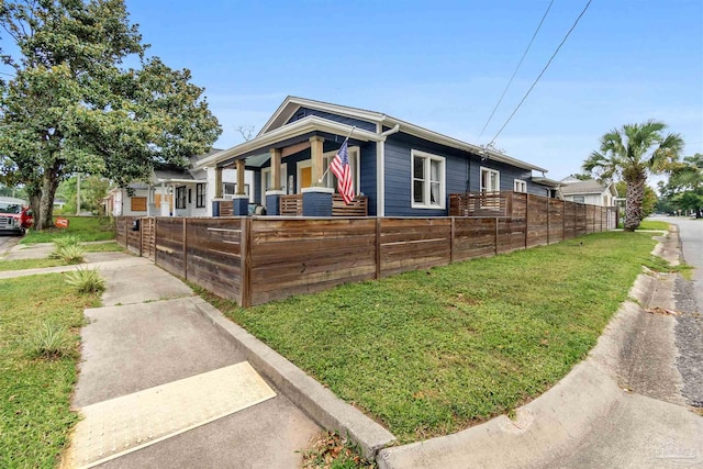 view of property exterior with a fenced front yard and a yard