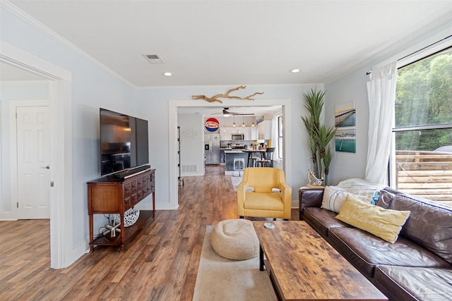 living room featuring recessed lighting, dark wood-type flooring, visible vents, baseboards, and ornamental molding