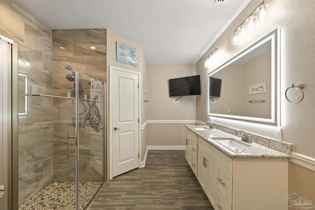 bathroom with hardwood / wood-style flooring, vanity, and a shower with shower door