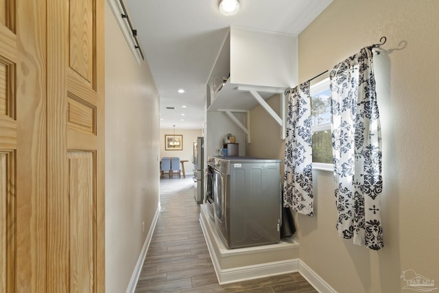 hall featuring independent washer and dryer and a barn door