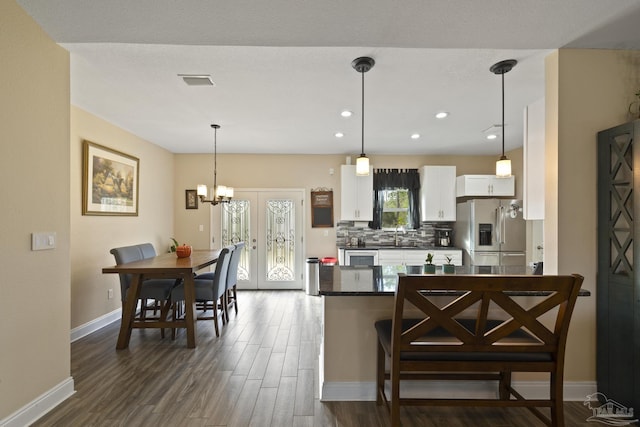 kitchen featuring hanging light fixtures, tasteful backsplash, white cabinets, stainless steel fridge with ice dispenser, and french doors