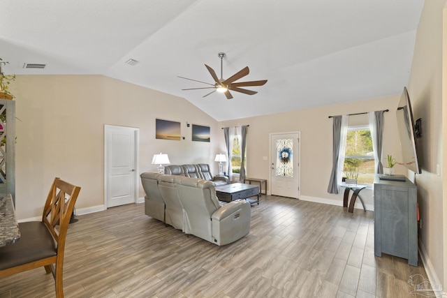 living room featuring vaulted ceiling, ceiling fan, and light hardwood / wood-style flooring