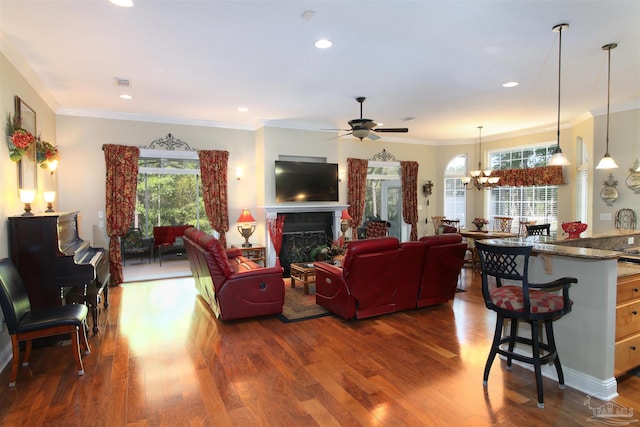 living room with dark wood-style flooring, visible vents, a fireplace, ceiling fan with notable chandelier, and recessed lighting