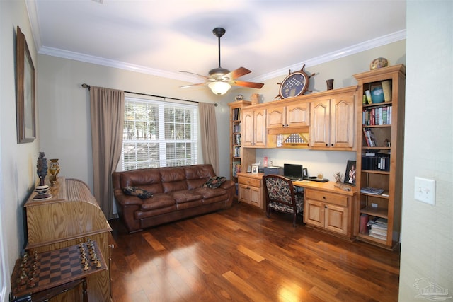 office space featuring dark wood-type flooring, a ceiling fan, crown molding, and built in desk