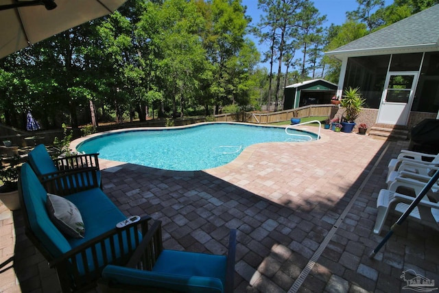 view of swimming pool featuring a sunroom, a fenced backyard, a patio area, and a fenced in pool