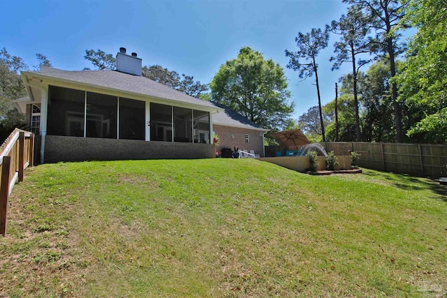 view of yard featuring a fenced backyard and a sunroom