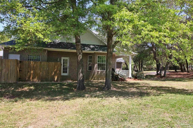 view of front of property with fence, a front lawn, and brick siding