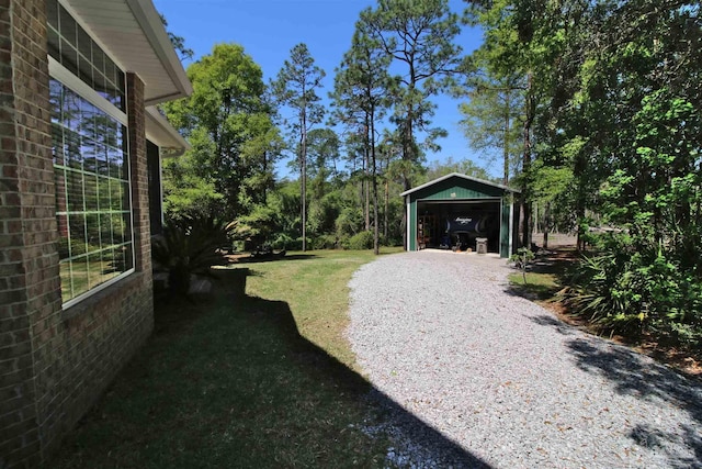 view of yard featuring an outbuilding and gravel driveway