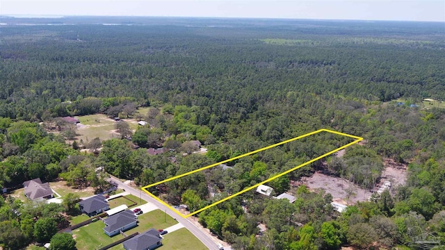 drone / aerial view with a wooded view