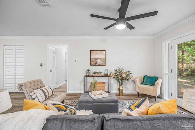 living room featuring hardwood / wood-style floors, ceiling fan, and crown molding