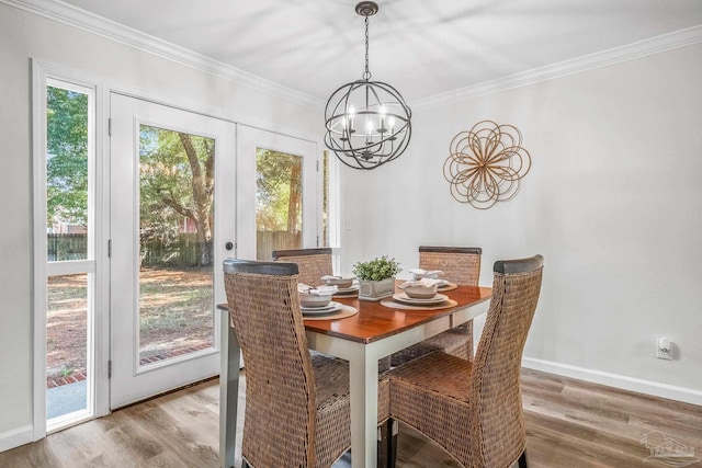 dining room with ornamental molding, light hardwood / wood-style flooring, and french doors