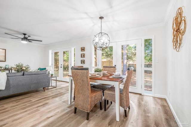 dining room featuring french doors, light wood-type flooring, and crown molding