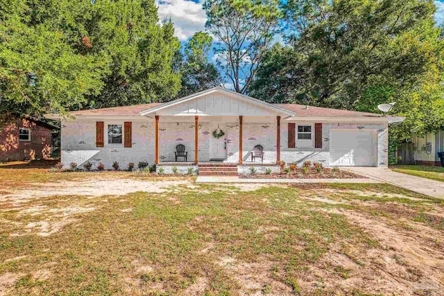 ranch-style home featuring covered porch, a front yard, and a garage