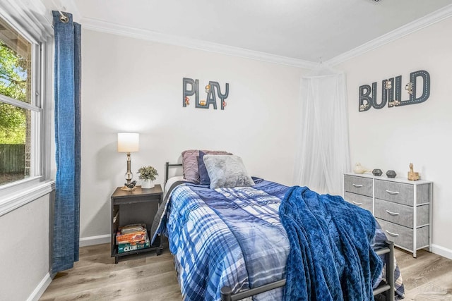 bedroom with wood-type flooring, crown molding, and multiple windows